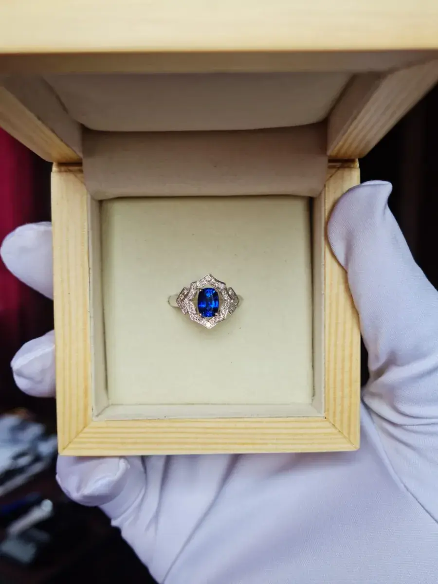 Cushion-cut Ceylon blue sapphire ring with diamond frame in its presentation box