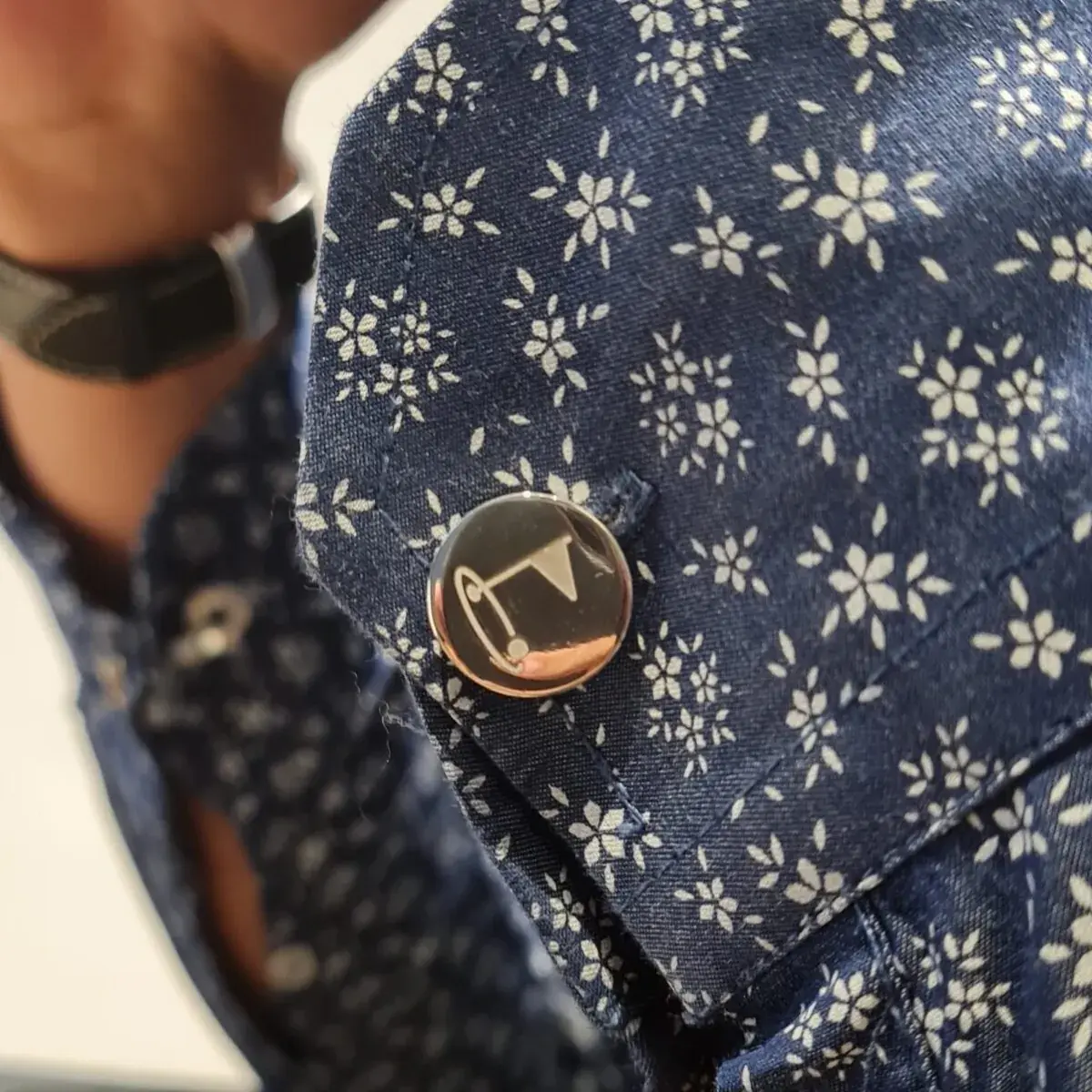 Engraved rose gold button cover styled on a patterned navy shirt